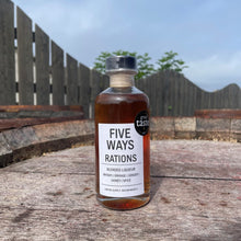 Load image into Gallery viewer, Bottle of 'Five Ways Rations' blended liqueur on a wooden surface with a blurred background